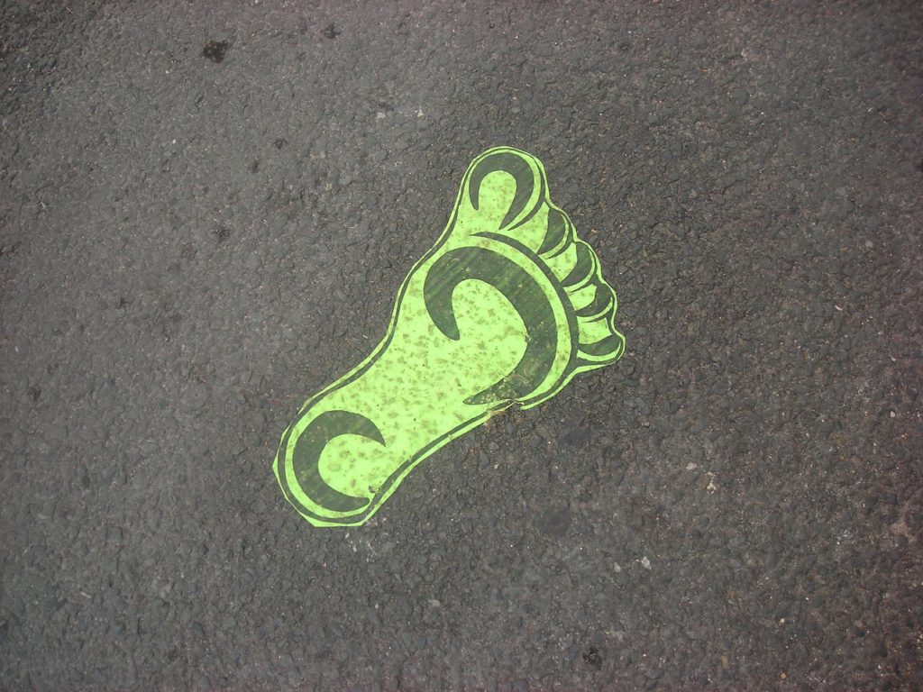 huella verde sobre asfalto